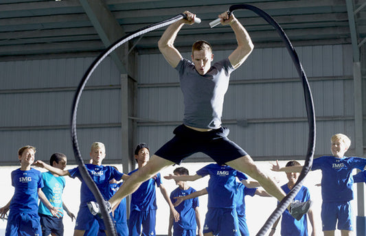 Coach uses battle ropes at team workout