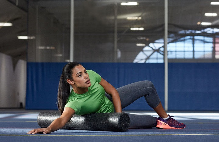 Woman uses foam roller in gym