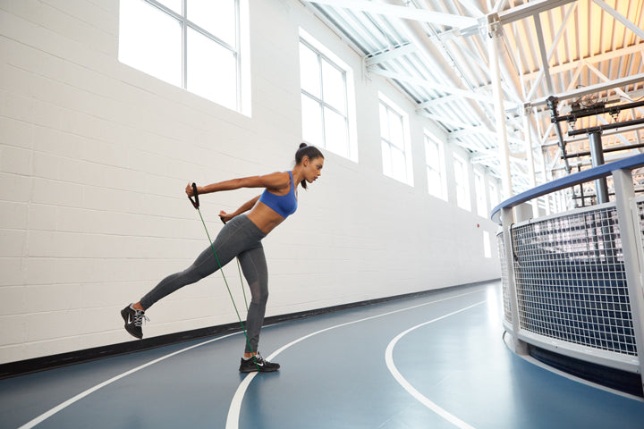 Woman in gym does exercise band workout